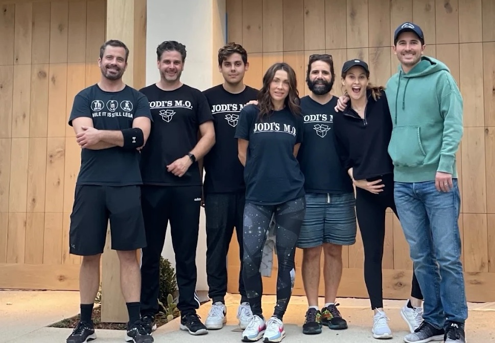 The Jodi's M.O. crew in branded shirts outside a client's home